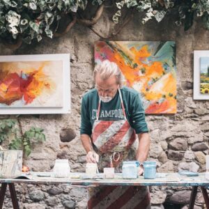 Older man mixing paints in his studio