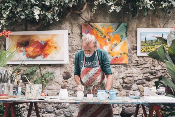 Older man mixing paints in his studio