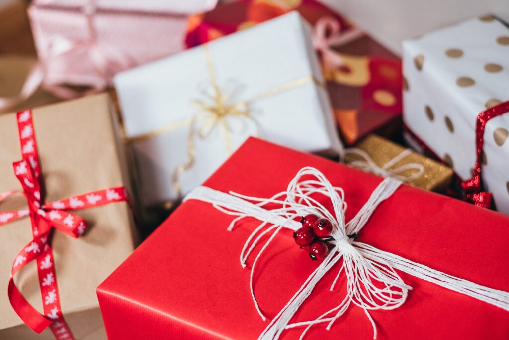 Christmas presents beautifully wrapped up in red, brown, white and gold paper and ribbons and string. 