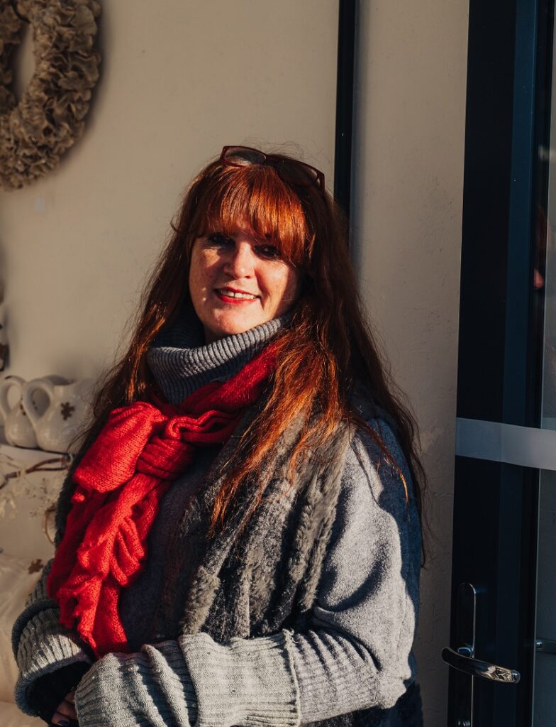 Karen, owner of Puzzle Boutique, selling Scandi Fashion, stands in the door way of her shop